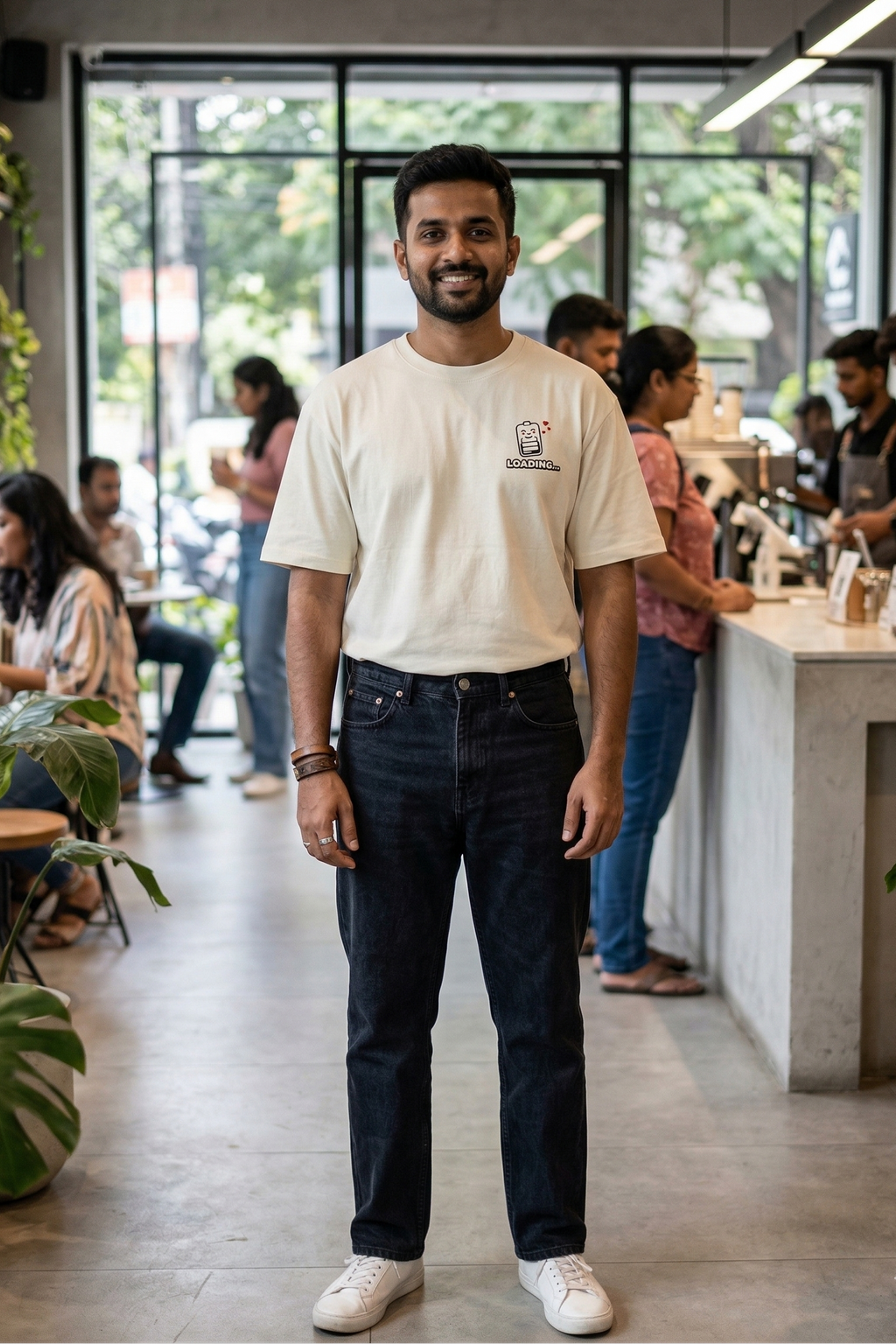 Man wearing a white t-shirt with a logo in a casual setting
