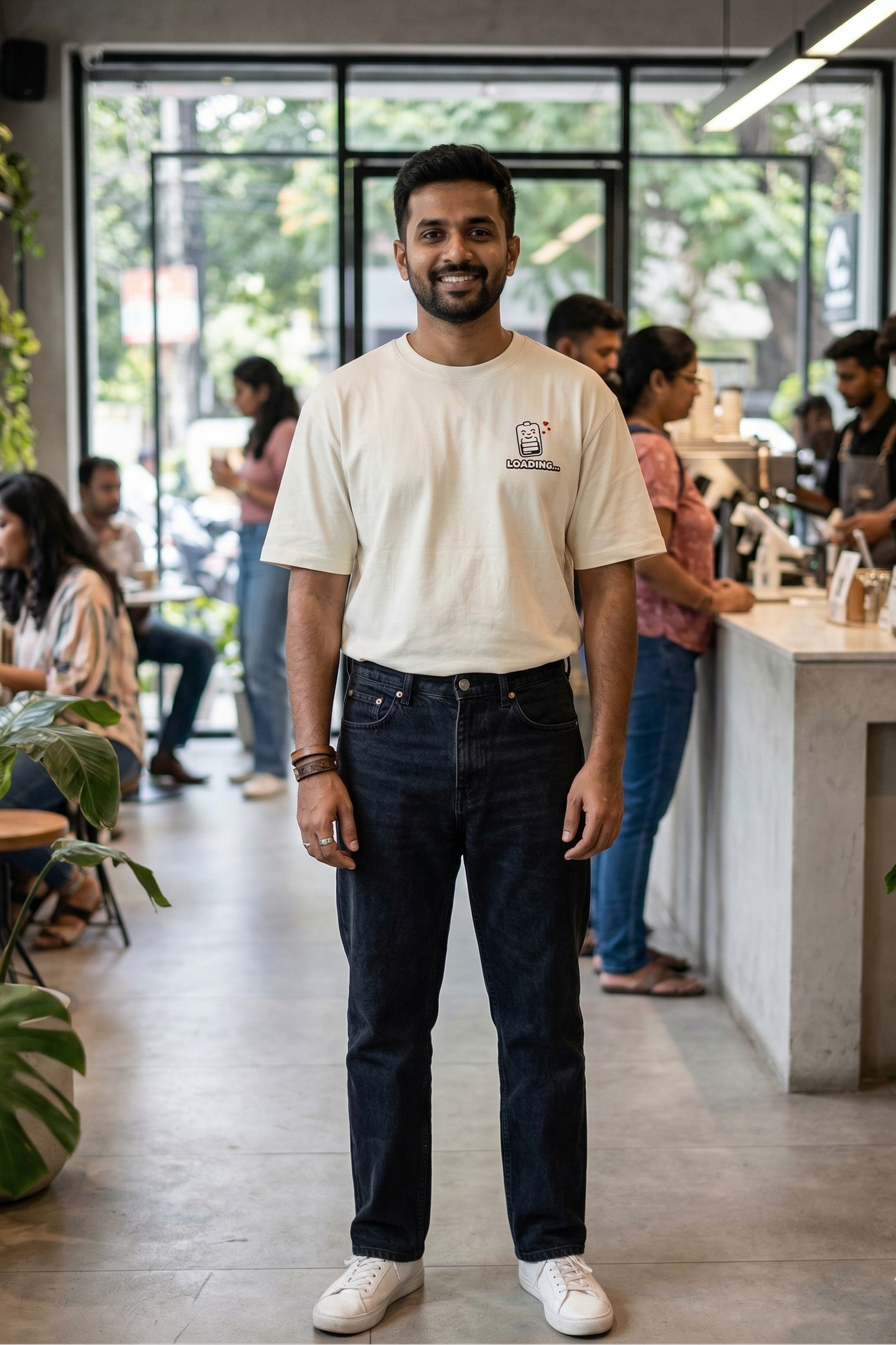 Man wearing a white t-shirt with a logo in a casual setting