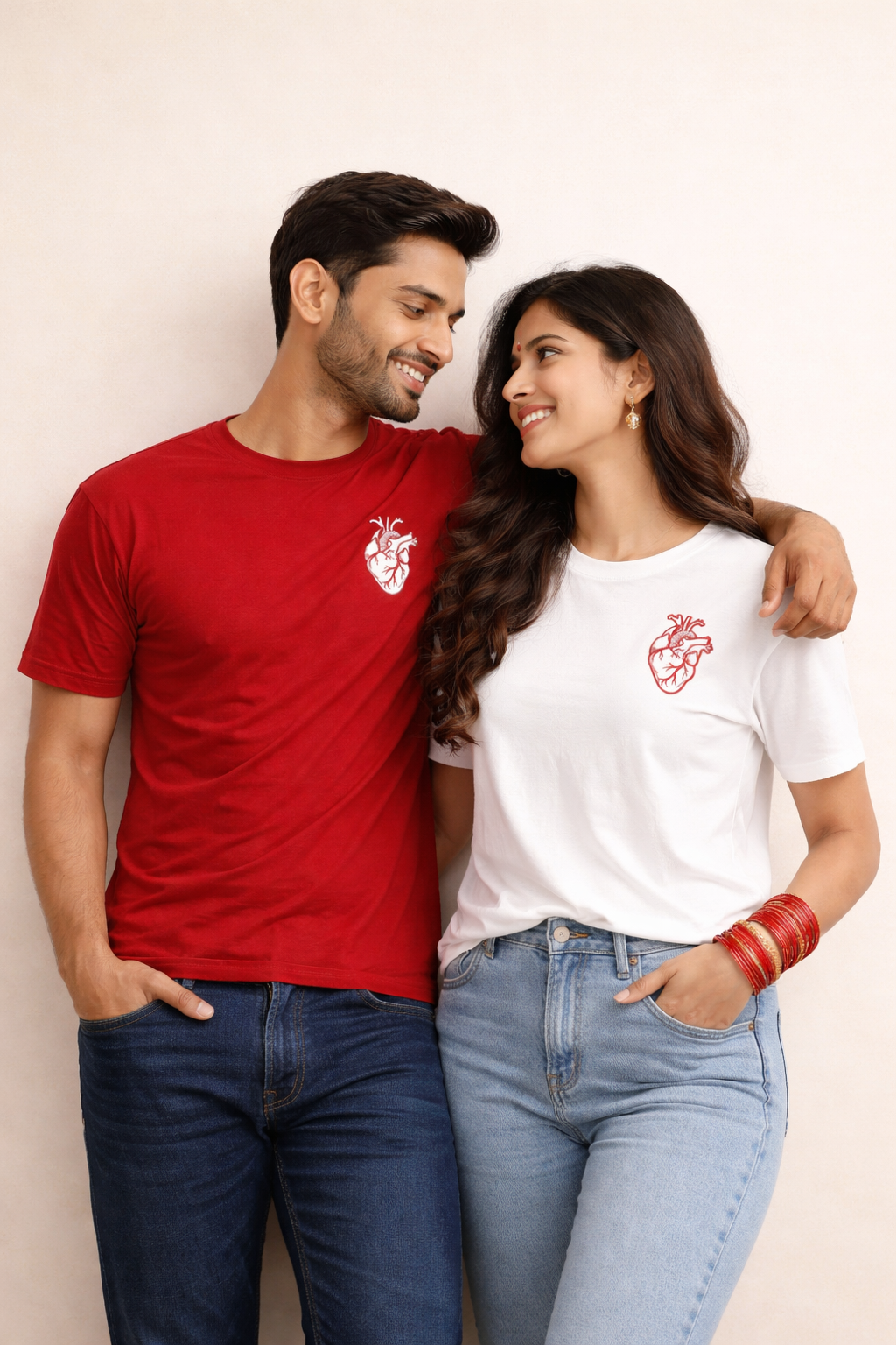 Man and woman wearing matching t-shirts with a heart design on a plain background