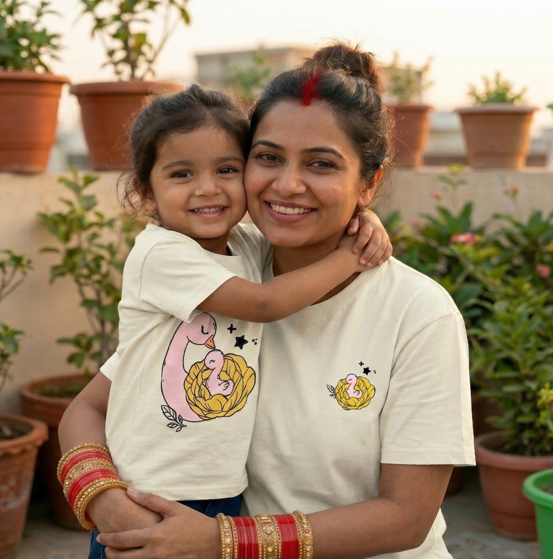 Woman and child wearing matching t-shirts with a duck design on a rooftop with plants in the background