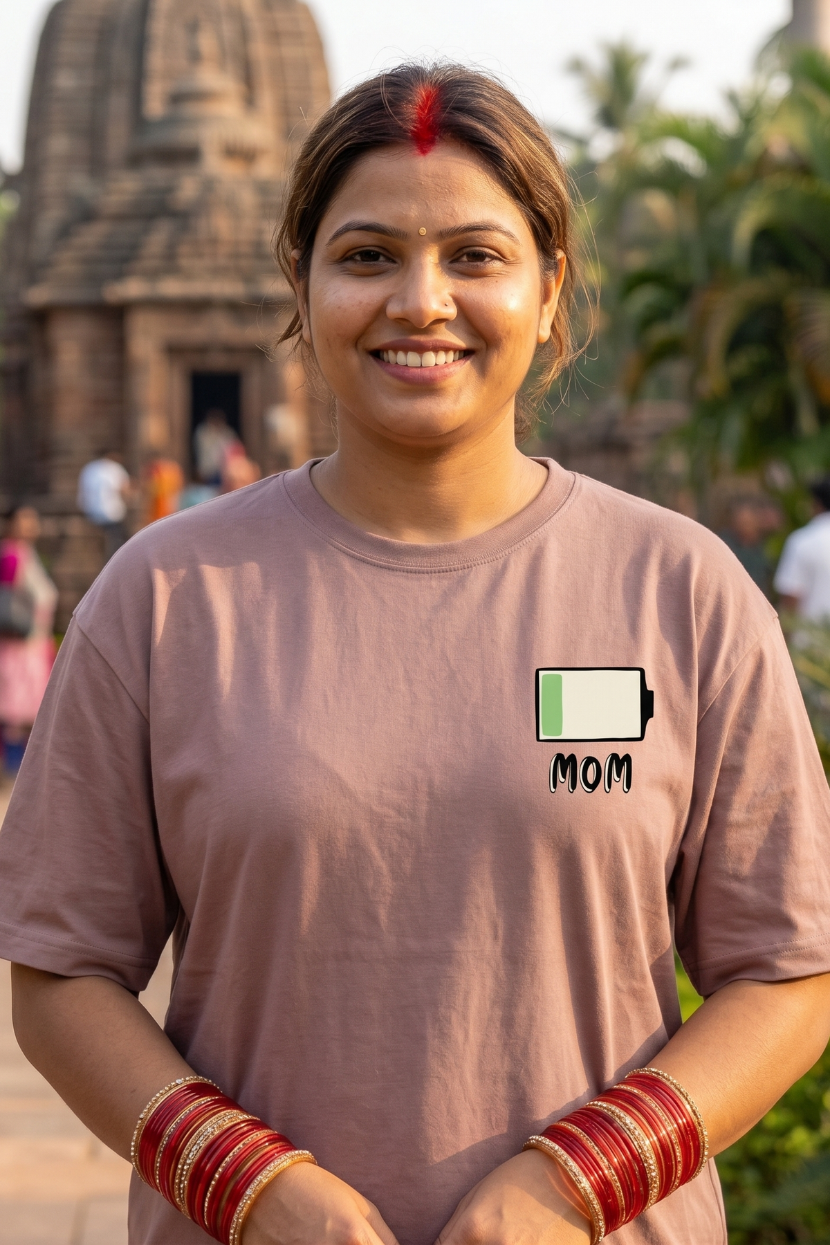 Woman wearing a charcoal unisex cotton T-shirt with a MOM battery graphic, part of the Vista Studio Mom Collection.
