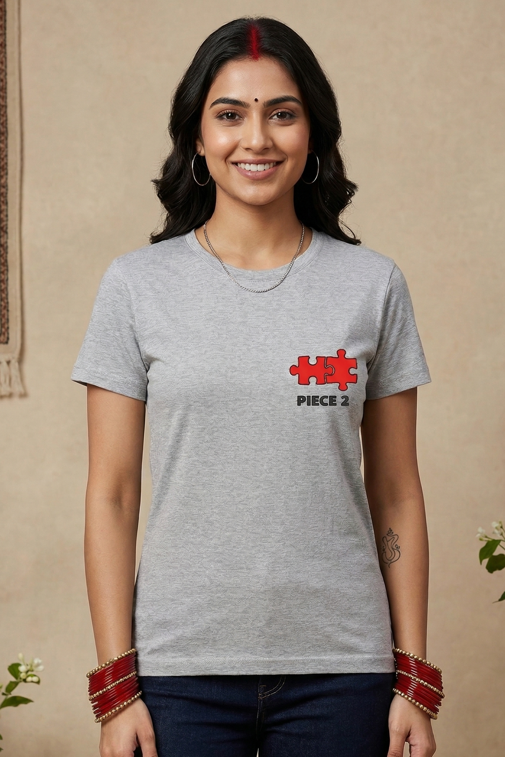 Woman wearing a gray t-shirt with a red and white logo indoors.