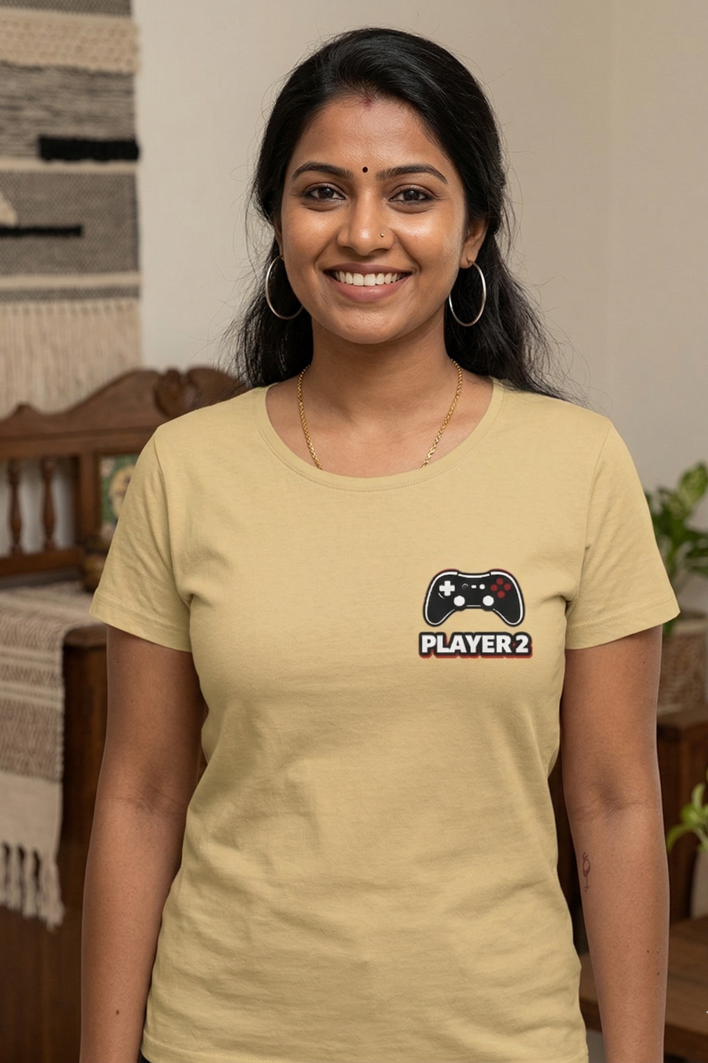 Woman wearing a beige t-shirt with a graphic design in a home setting