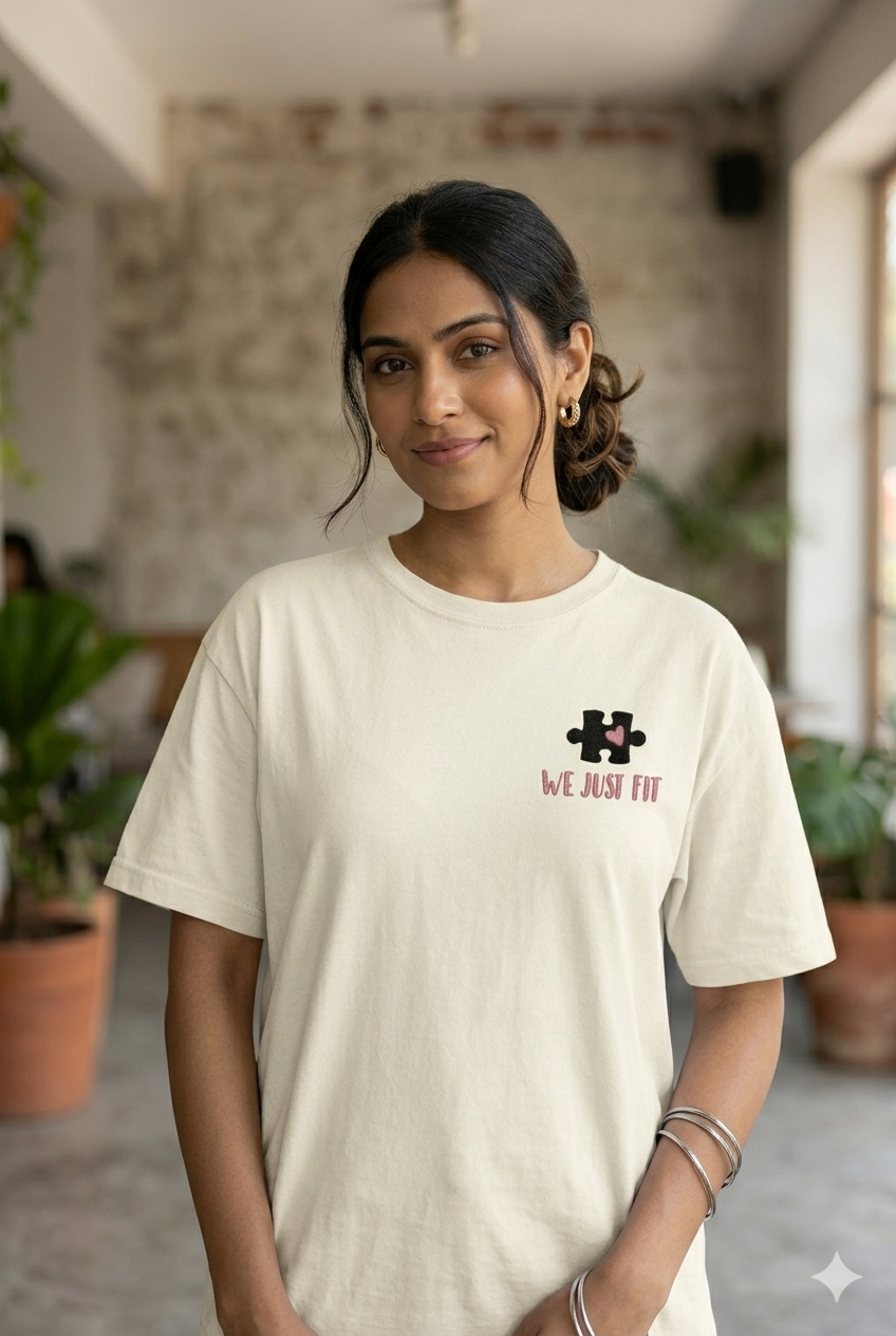 Woman wearing a white t-shirt with a logo and text in an indoor setting